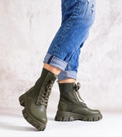 Person wearing Bravelle insulated rubber boots with elastic upper and high shaft, showcasing modern utility and urban edge.