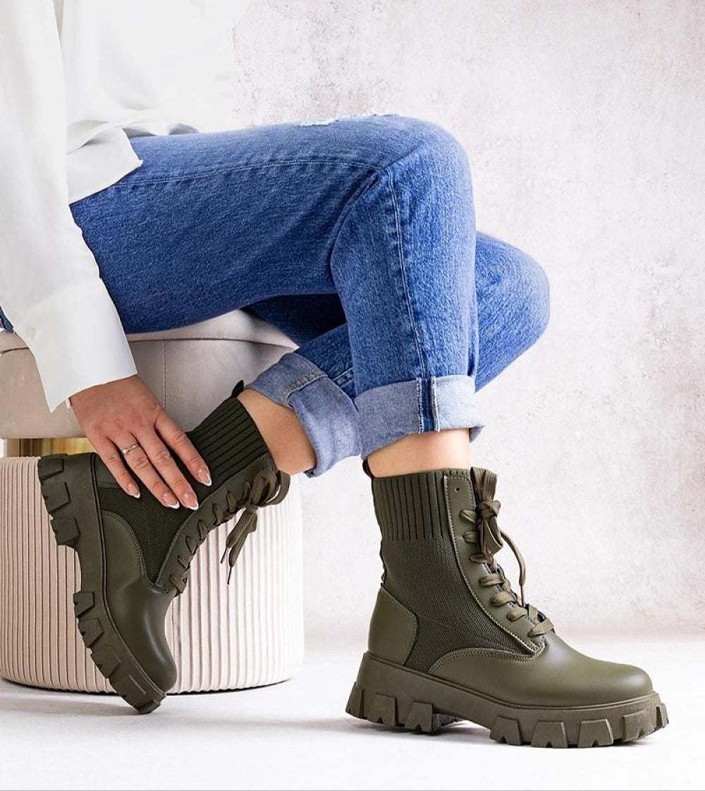 Person wearing green Bravelle insulated rubber boots with jeans, showcasing modern utility and style. Ideal for autumn-to-winter wear.