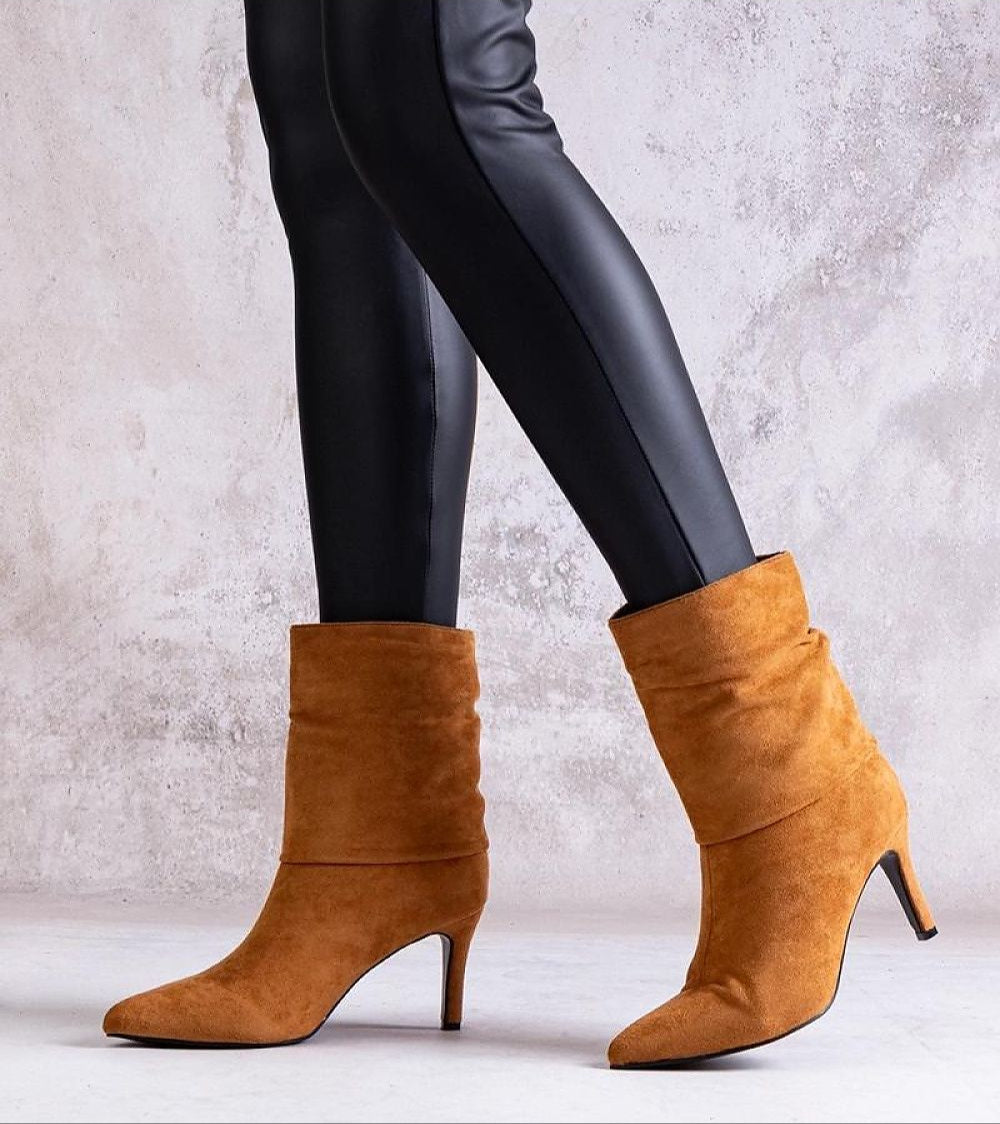 Narelle stiletto heel boots with suede-look texture, worn with black leggings, showcasing poised feminine silhouette and slip-on design.