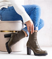 Woman wearing Nuvarelle stiletto ankle boots with jeans, showcasing elegance and functionality for autumn styling.