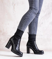 Woman wearing black Nuvarelle Stiletto Ankle Boots with gray jeans, showcasing elegance and functionality for autumn fashion.