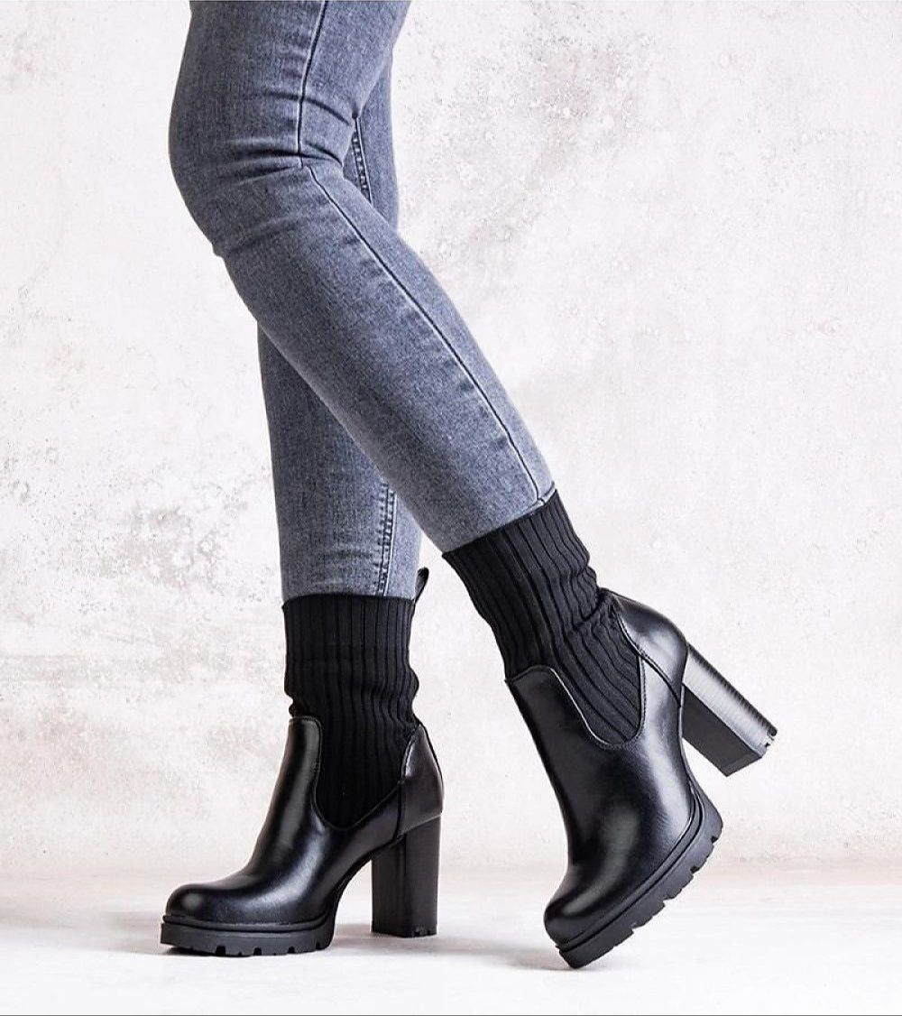 Woman wearing black Nuvarelle Stiletto Ankle Boots with dark jeans, showcasing elegant and functional autumn footwear.