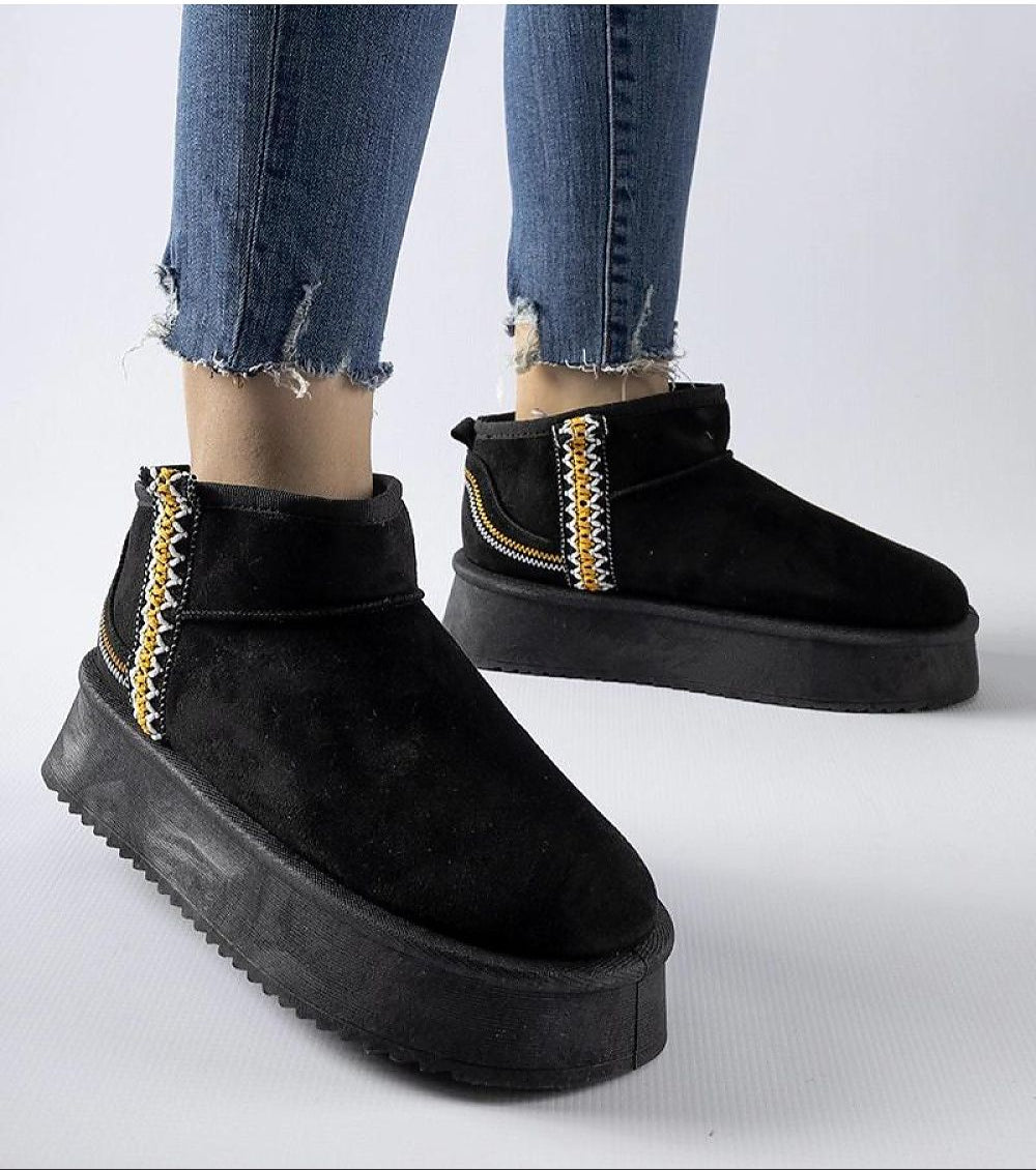 Person wearing black Orvanna Insulated Platform Snow Boots with eco leather, slip-on design, and 5 cm platform heel for winter style.