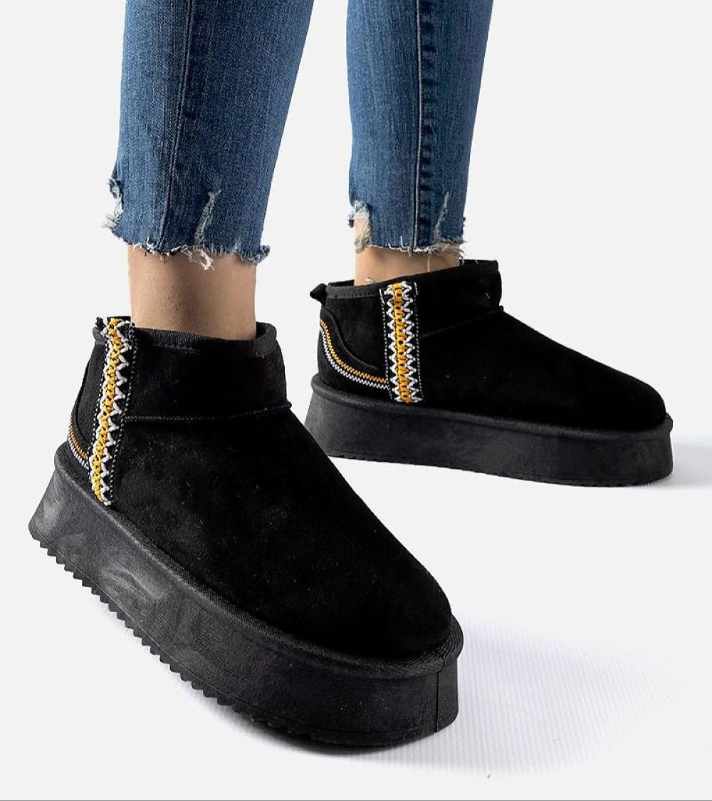 Woman wearing Orvanna Insulated Platform Snow Boots in black eco leather with platform heel and slip-on design.