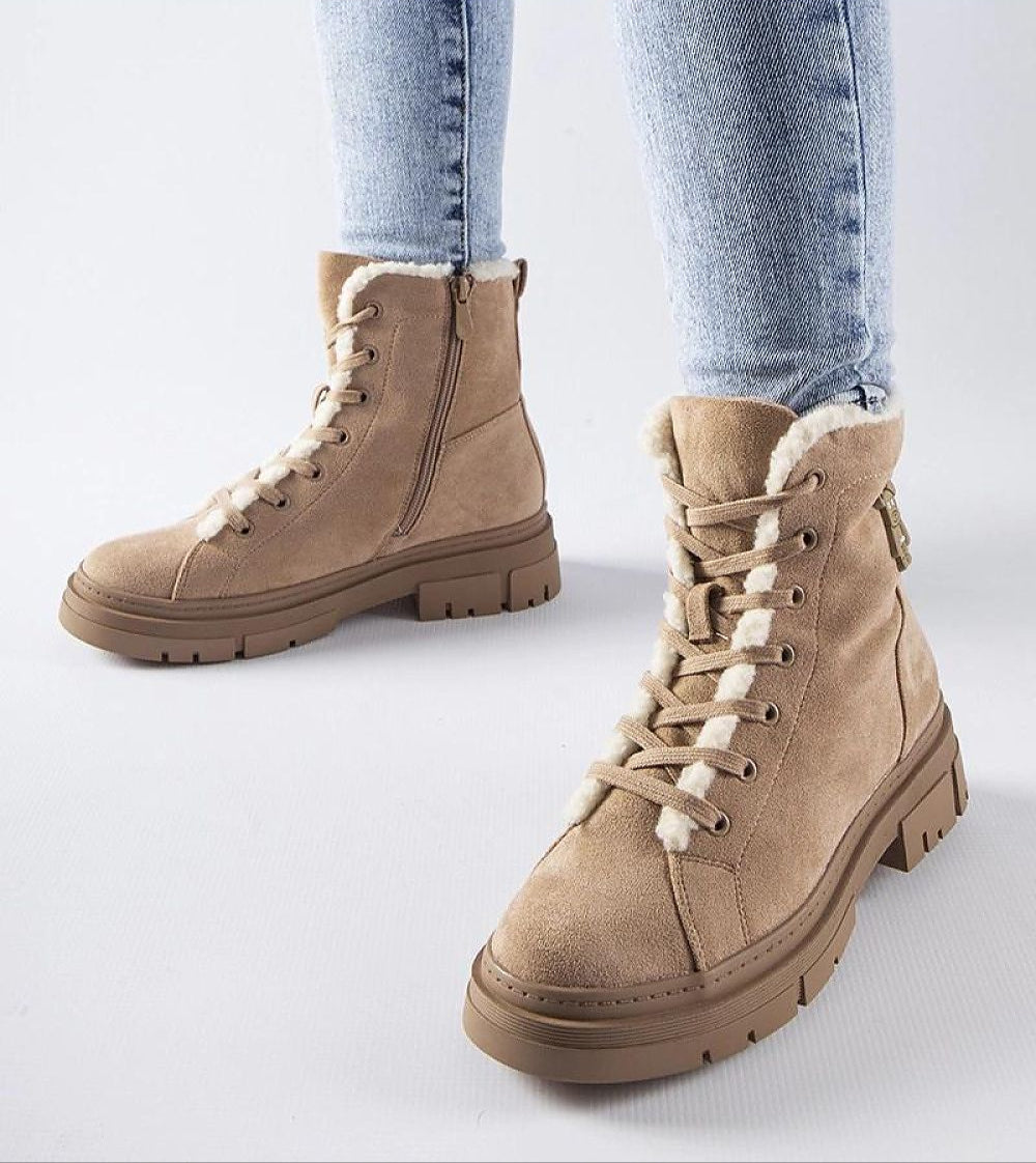 Beige platform suede boots with side zipper, worn with light blue jeans, showcasing modern design and comfort for winter fashion.