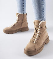 Beige platform suede boots with side zipper, worn with light blue jeans, showcasing modern design and comfort for winter fashion.