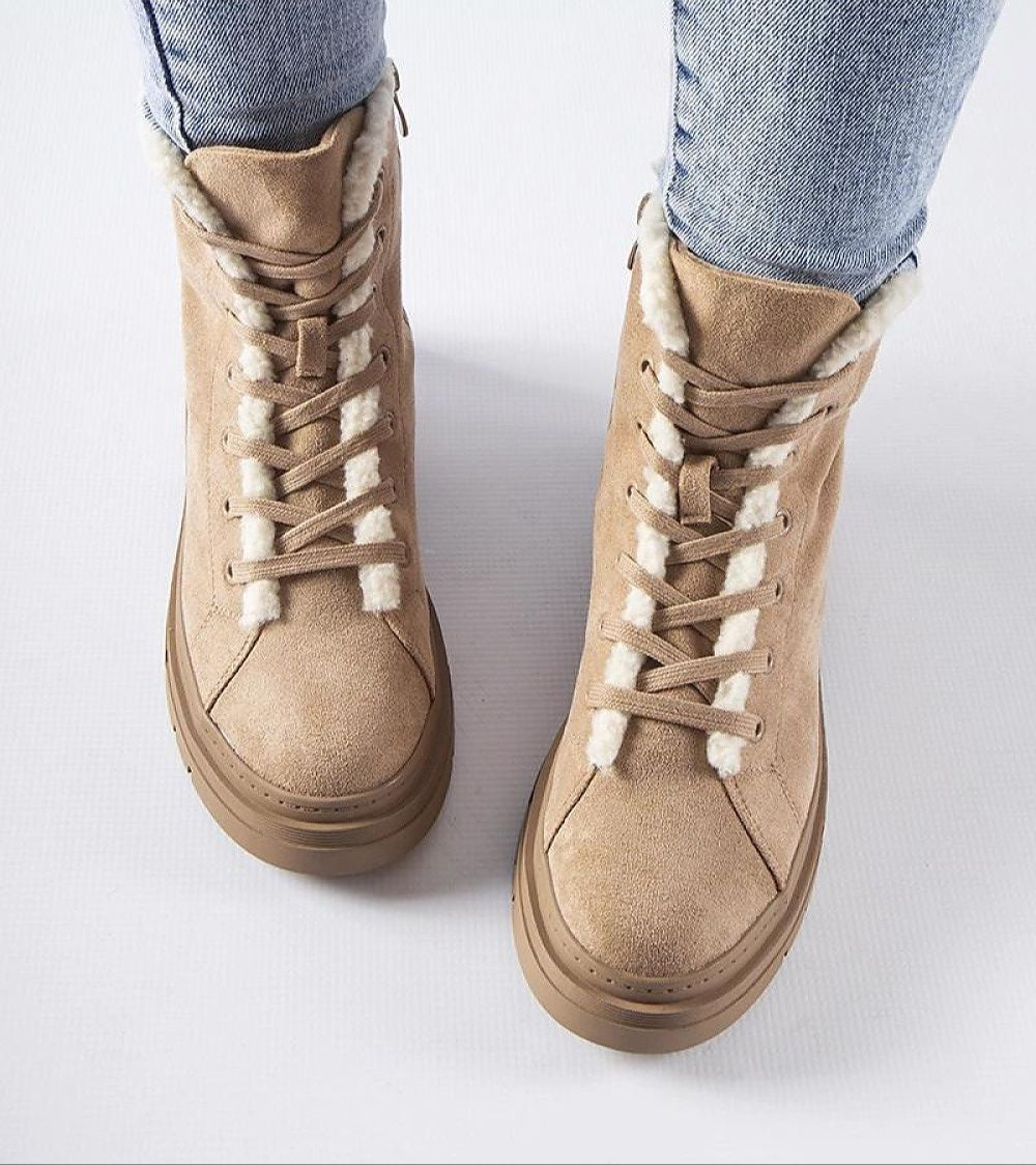 Beige suede platform boots with white fur lining and side zipper, perfect for winter wear, paired with blue jeans.