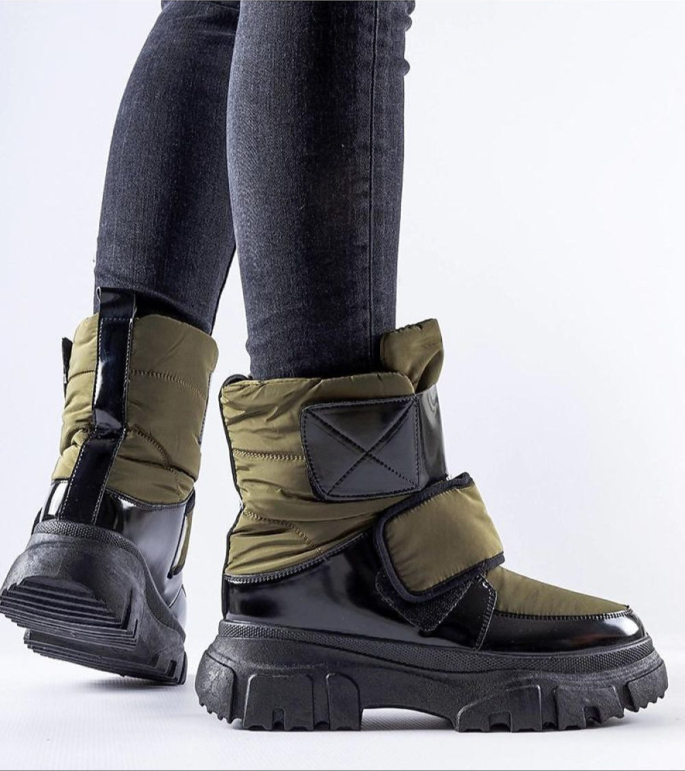 Person wearing Velgora Winter Grip Boots with insulated shaft, Velcro strap, and rubber sole for stability and warmth in snow.
