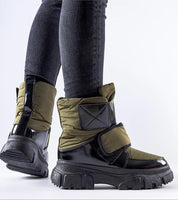 Person wearing Velgora Winter Grip Boots with insulated shaft, Velcro strap, and rubber sole for stability and warmth in snow.