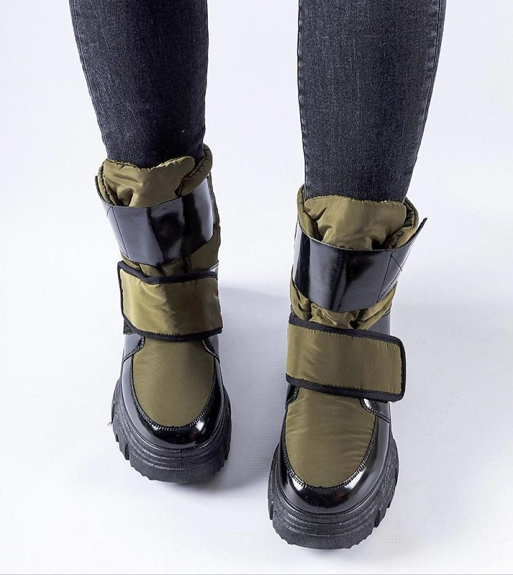 Person wearing Velgora Winter Grip Boots with green and black design, featuring adjustable Velcro strap and textured rubber sole for winter use.
