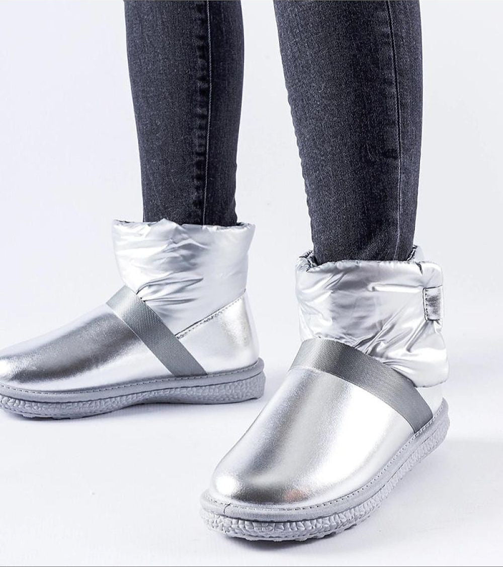 Woman wearing Brivona Glossy Velcro Snow Boots with rounded toes, 3 cm platform, silver finish, and Velcro closure for winter comfort.