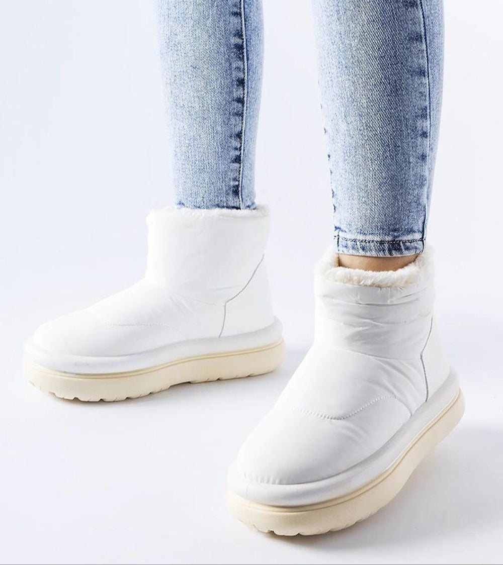 Person wearing Kirella Insulated Platform Snow Boots in white, showcasing cozy design and sleek slip-on style for winter fashion.
