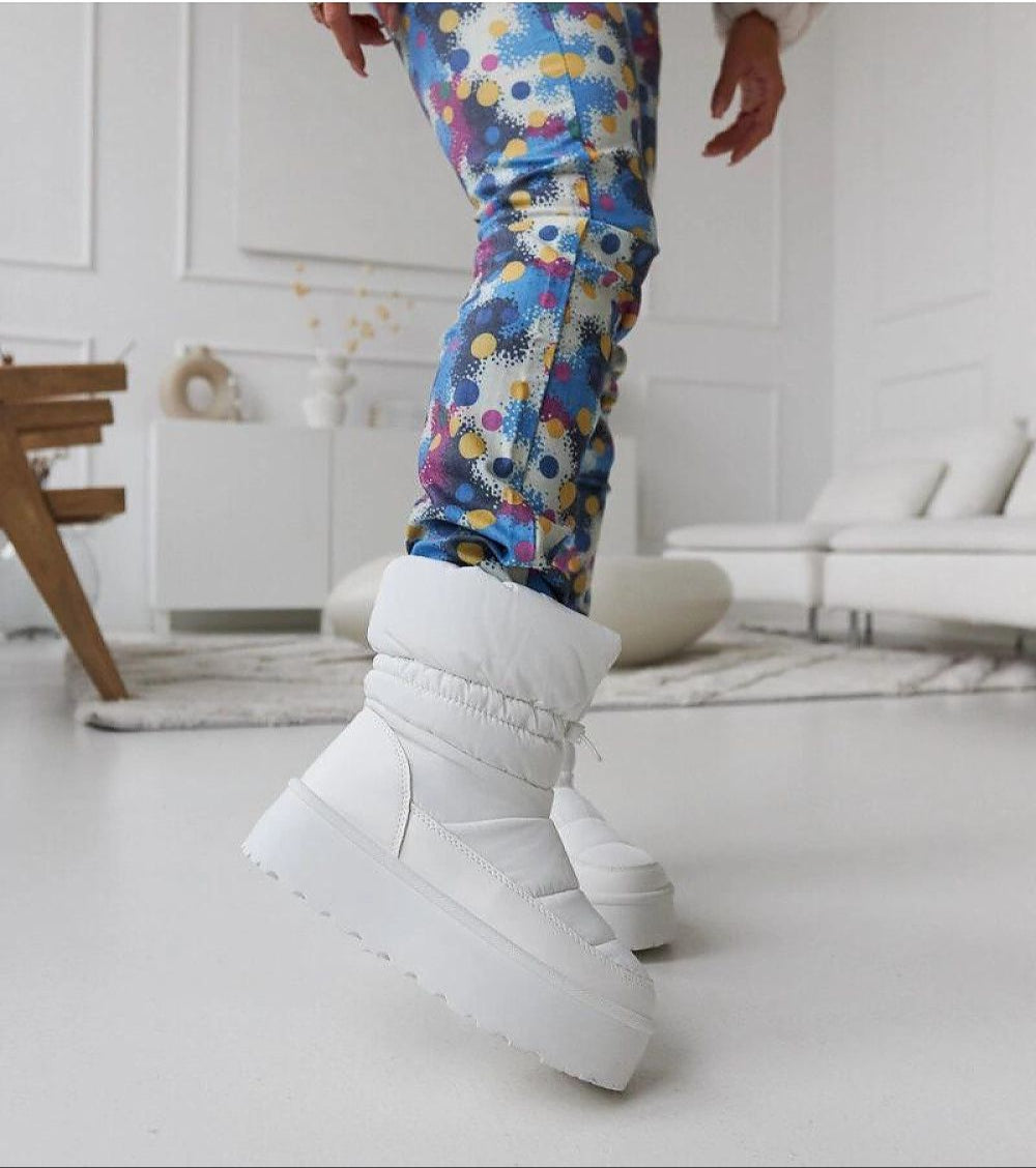 Person wearing Olviera Slip-On Platform Snow Boots with colorful leggings indoors, showcasing winter style and comfort.