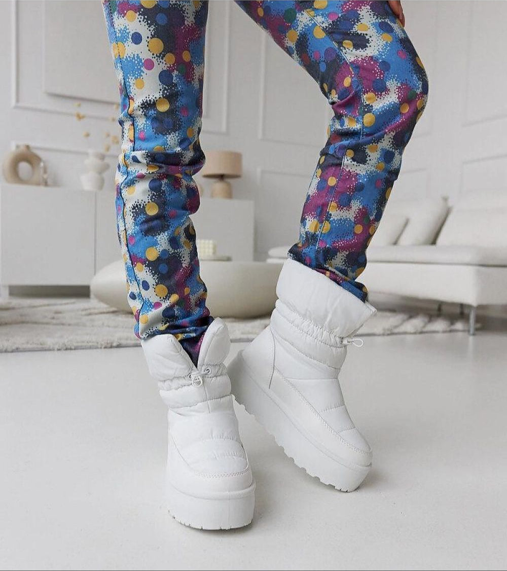 Woman wearing Olviera Slip-On Platform Snow Boots with colorful pants, showcasing winter fashion with comfort and bold design.