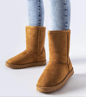 Person wearing brown Arlosa Insulated Slip-On Snow Boots with jeans, showcasing durable design for winter weather protection.