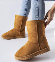 Person wearing Arlosa insulated slip-on snow boots in tan, demonstrating stylish ankle-high design and grip sole on jeans background