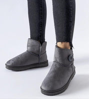 Ankle-high gray Narevik Slip-On Winter Snow Boots with button detail, worn with black jeans on a white background.