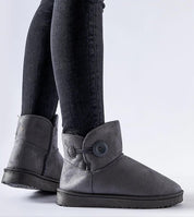 Person wearing Narevik Slip-On Winter Snow Boots, featuring ankle-high silhouette and button detail, ideal for cold, snowy days.