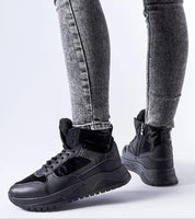 Person wearing Tharmin Winter Lace-Up Sneakers in black with gray jeans, highlighting high-top design and durable rubber sole for winter.