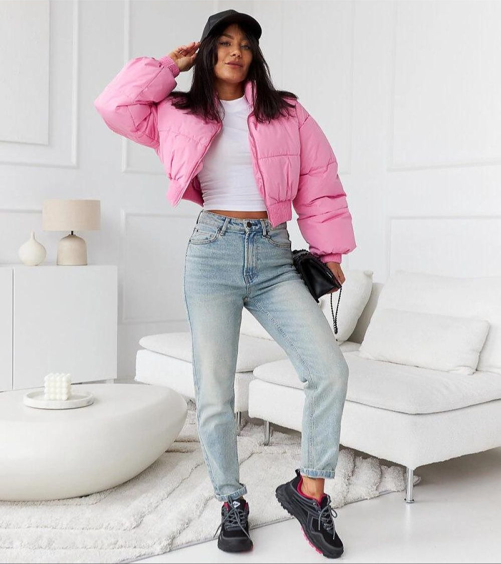 Woman in a pink jacket and jeans wearing Norvina Insulated Winter Sneakers in a stylish indoor setting.