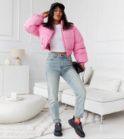 Woman in a pink jacket and jeans wearing Norvina Insulated Winter Sneakers in a stylish indoor setting.