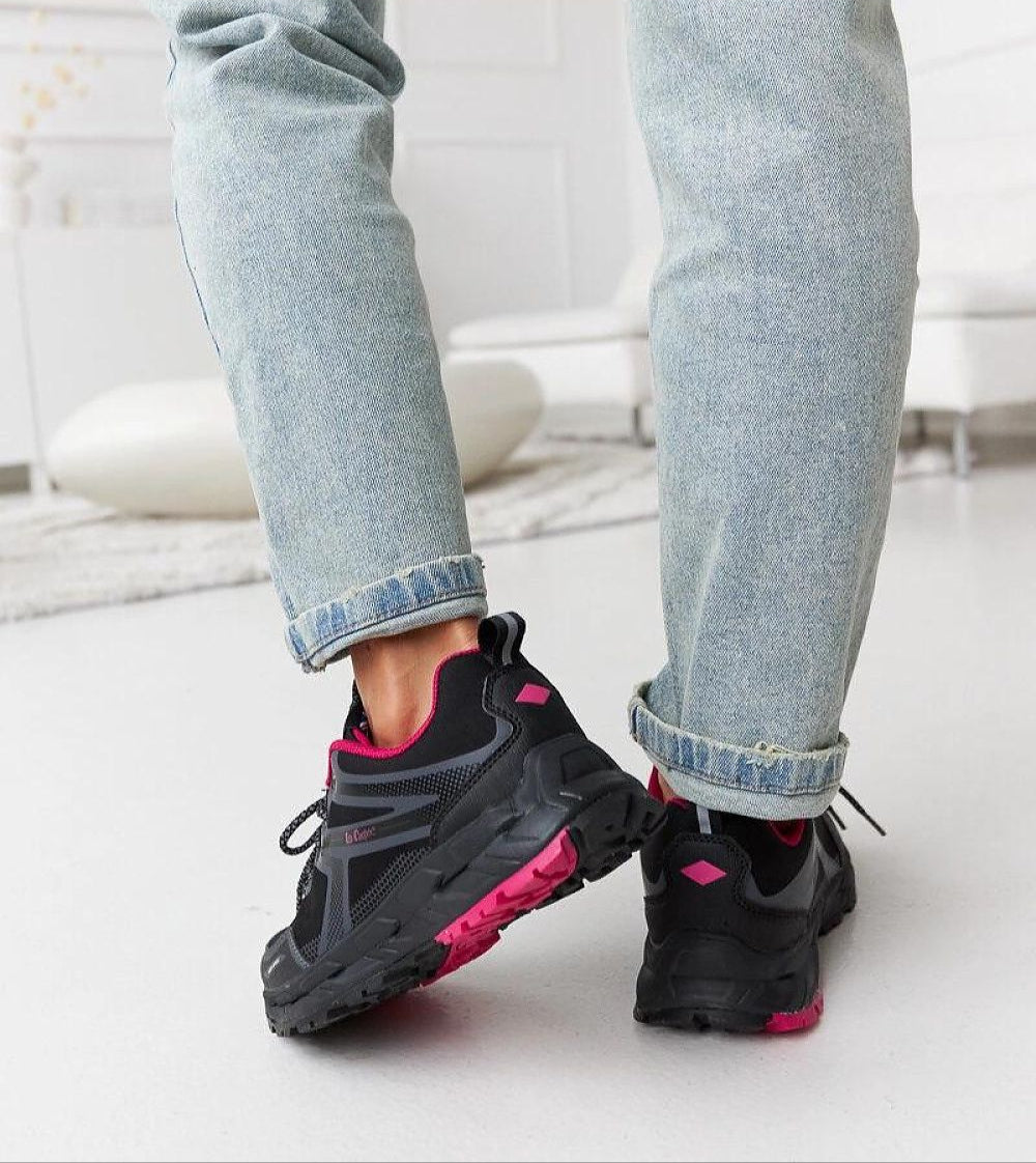 Person wearing black and pink Norvina Insulated Winter Sneakers with jeans in a cozy living room setting.