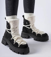 Person wearing Perivana Lace-Up Winter Baggers, black ankle-high boots with white lace, round toe, eco leather, warm lining, rubber sole.