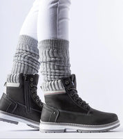 Veltrana waterproof insulated trappers in black with side zipper and high ankle cut, worn with grey socks and white pants.