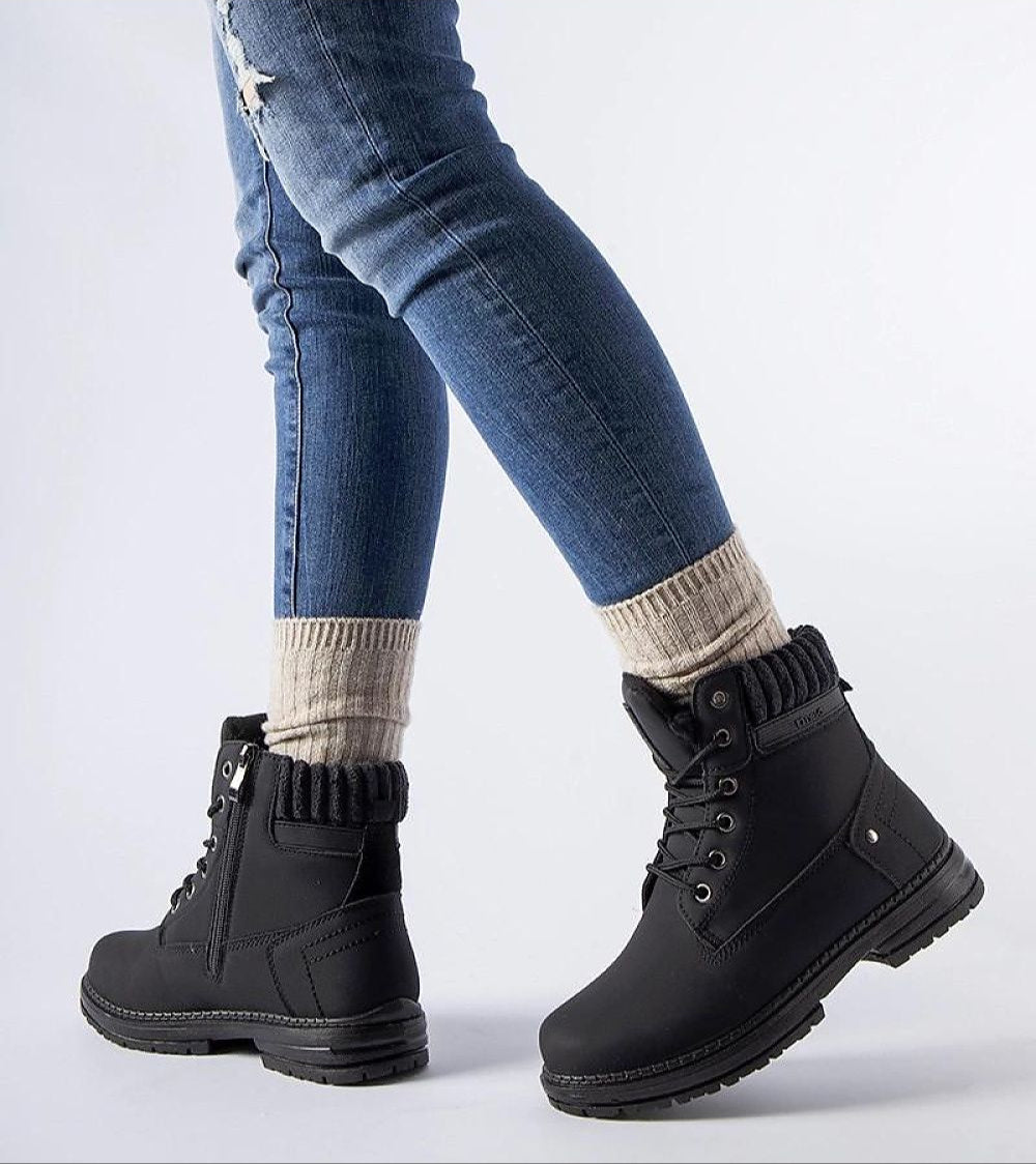 Person wearing Arauja Waterproof Insulated Trappers in black with knit socks, highlighting winter fashion and warmth.