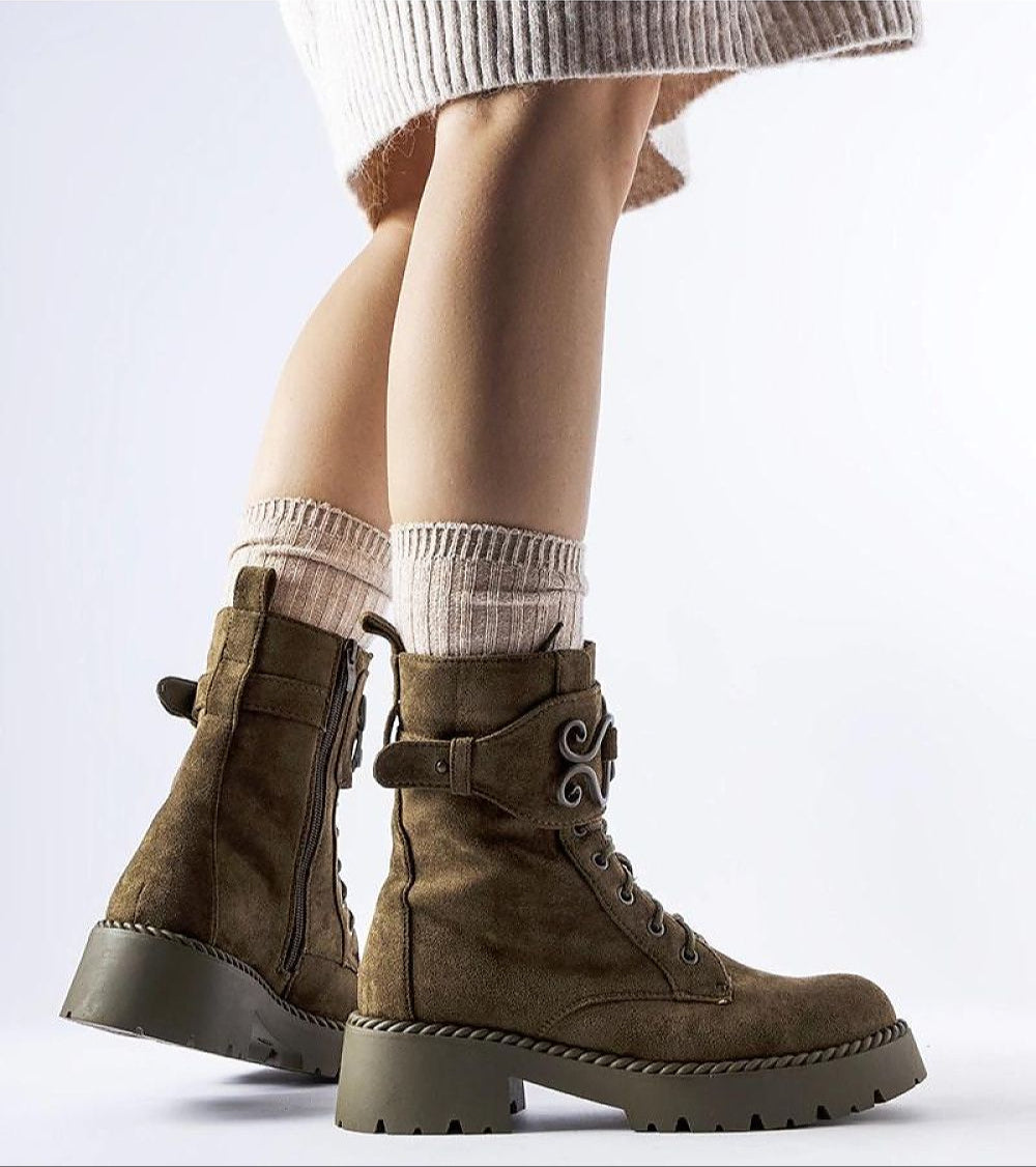 Person wearing Castore green suede platform boots with side zipper and elevated sole, showcasing winter fashion and practicality.