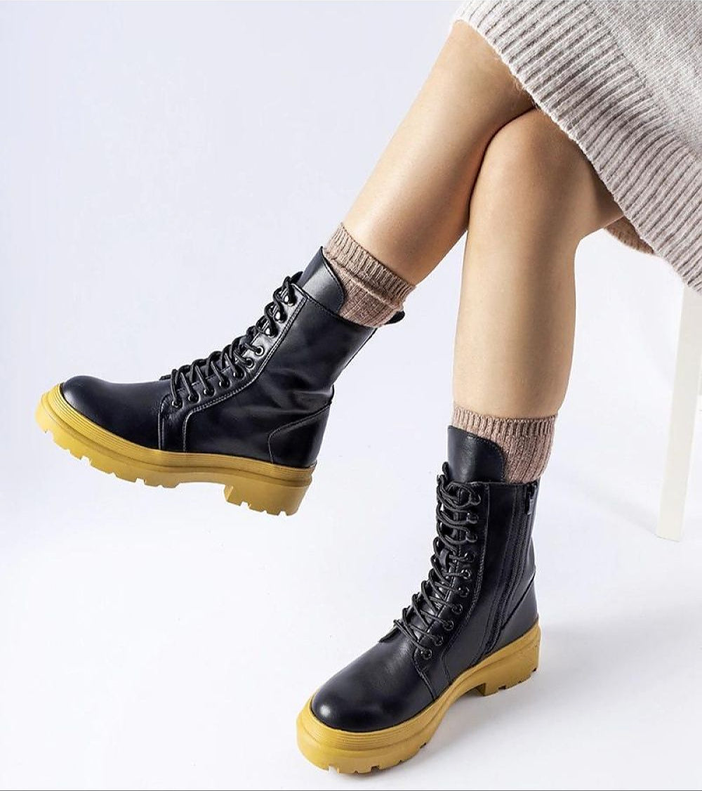 Black Vereliane Winter Boots with high ankle, rubberized exterior, round toe, flat heel, and side zipper, worn with beige socks.