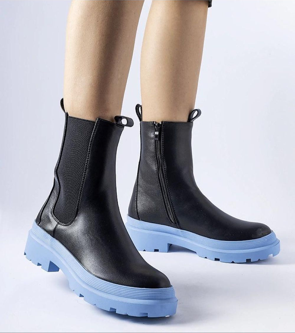Black ankle boots with blue soles and side zippers, showcasing modern style and practical design.
