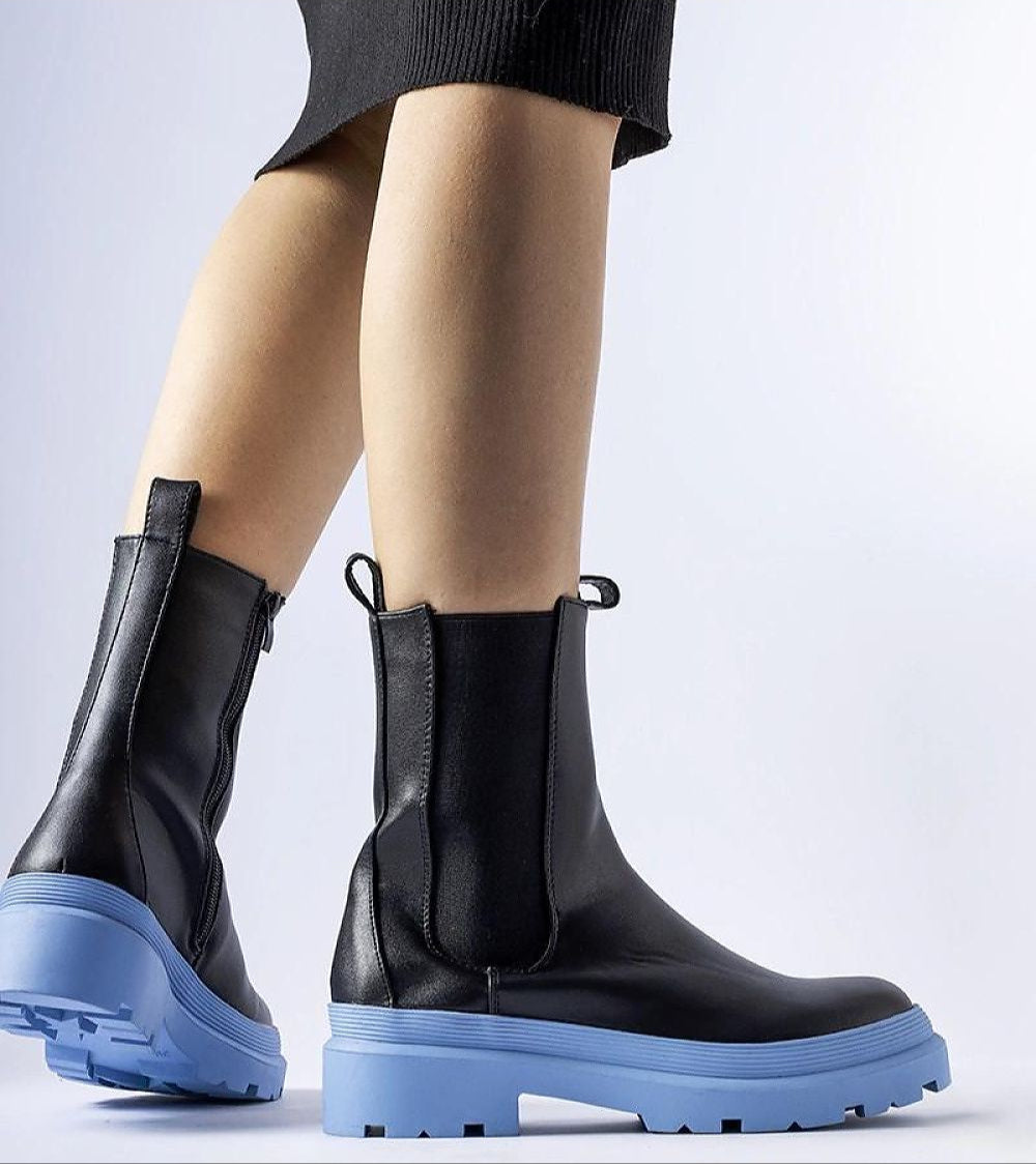 Close-up of Vereliane ankle boots with blue soles and vegan leather upper, showcasing modern design and functionality for winter fashion.