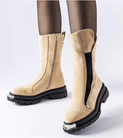 Beige mid-heel boots with side zipper and decorative sole, worn with black fishnet stockings, showcasing stylish winter footwear.