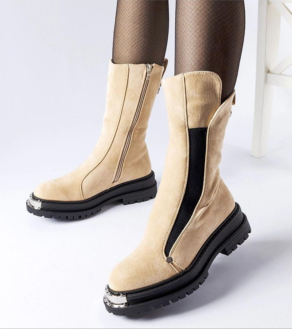 Beige mid-heel insulated boots with side zipper, black contrast and treaded sole, worn with fishnet tights for stylish winter comfort.