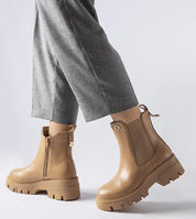 Chic Medanira platform insulated boots in tan with side zipper, offering style and warmth, paired with gray pants for a winter-ready look.
