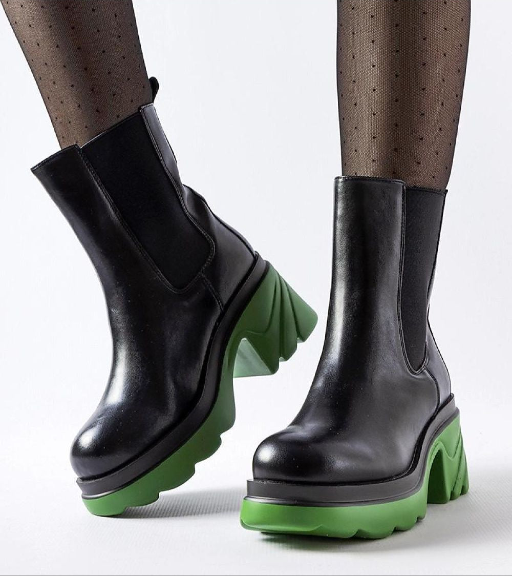 Black high-heel winter boots with green soles, showcasing a modern design with a bold block heel and slip-on style, ideal for cold weather.
