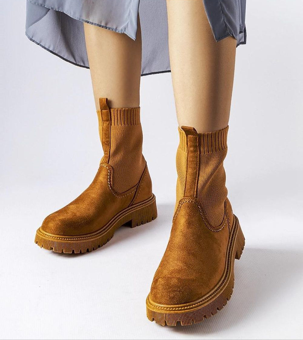 Solmare Eco-Suede Slip-On Boots with brown upper, medium heel, and rubber sole, showcasing stitch detail for autumn fashion.