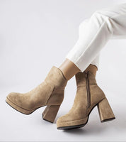 Woman wearing Elarin High-Heeled Gray Boots with a 9 cm block heel and zipper closure, styled with white pants on a neutral background.