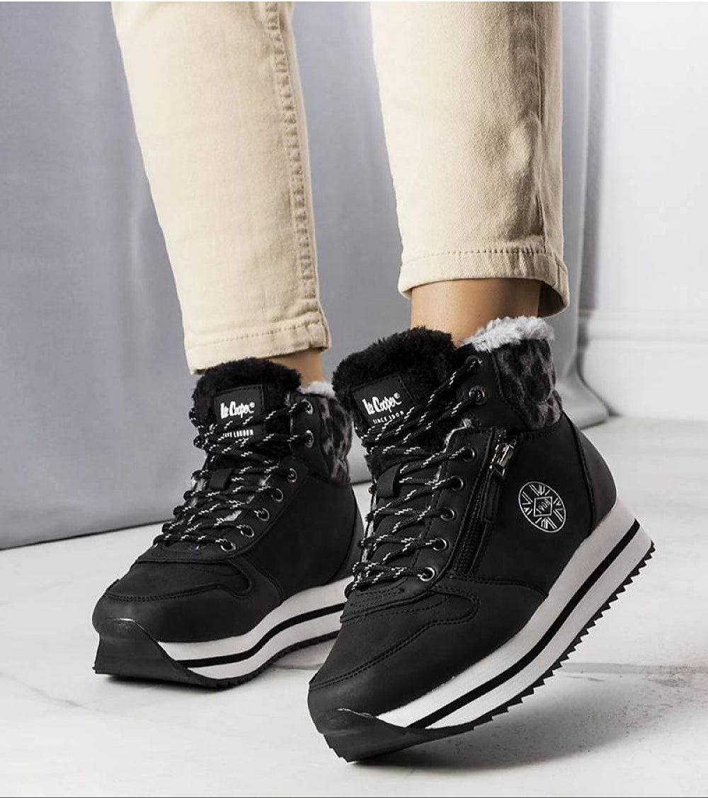 Person wearing Navarros Insulated Street Boots in black eco leather with white soles and faux fur lining, perfect for winter.