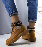 Brown leather trapper boots with fur lining, perfect for winter adventures. Features a flat rubber sole and lace-up front for secure fit.