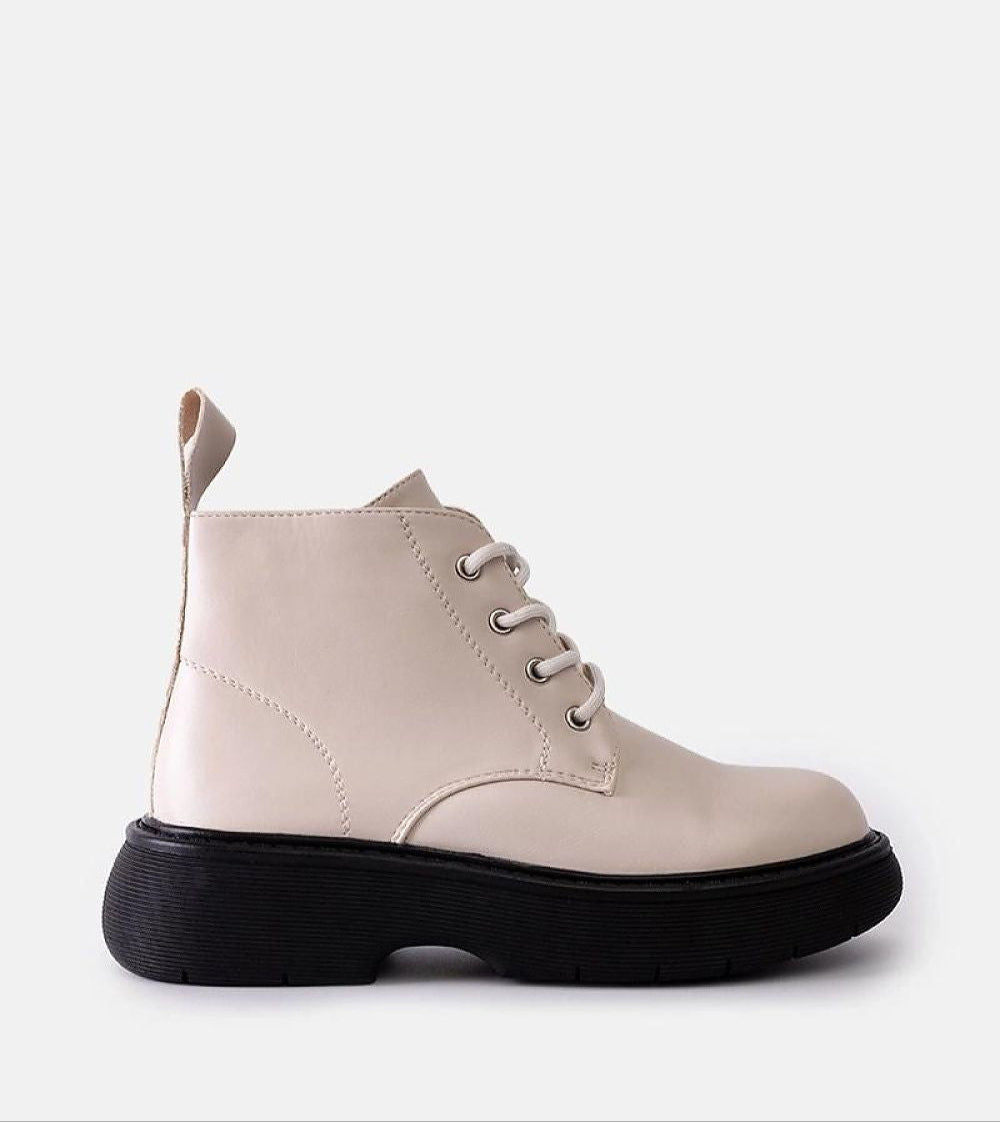 Solvaira matte white lace-up boots with thick treaded sole, showcasing minimalist urban style and eco leather craftsmanship.