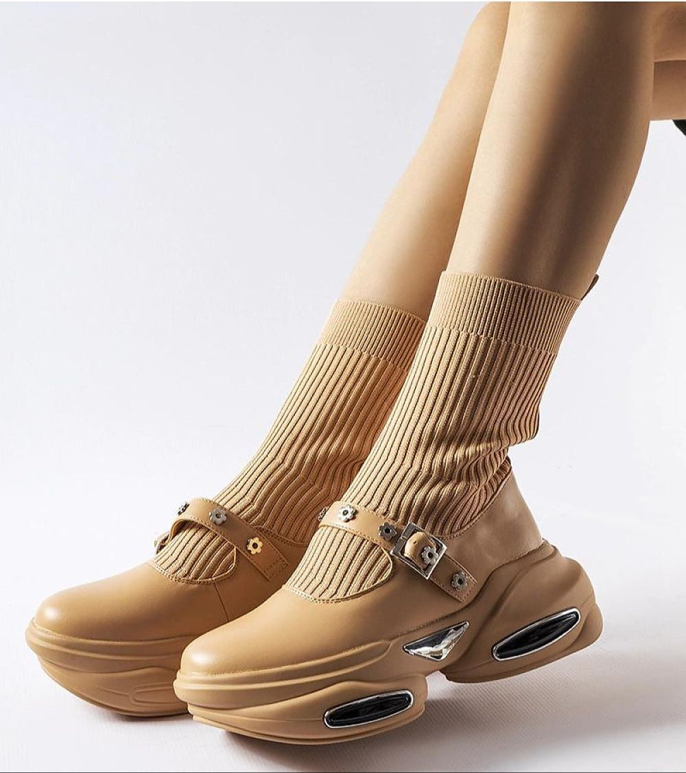 Beige stretch knit ankle boots with a thick sculpted heel, showcasing a sock-like shaft and rounded toe for modern style and comfort.