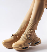 Beige stretch knit ankle boots with a thick sculpted heel, showcasing a sock-like shaft and rounded toe for modern style and comfort.