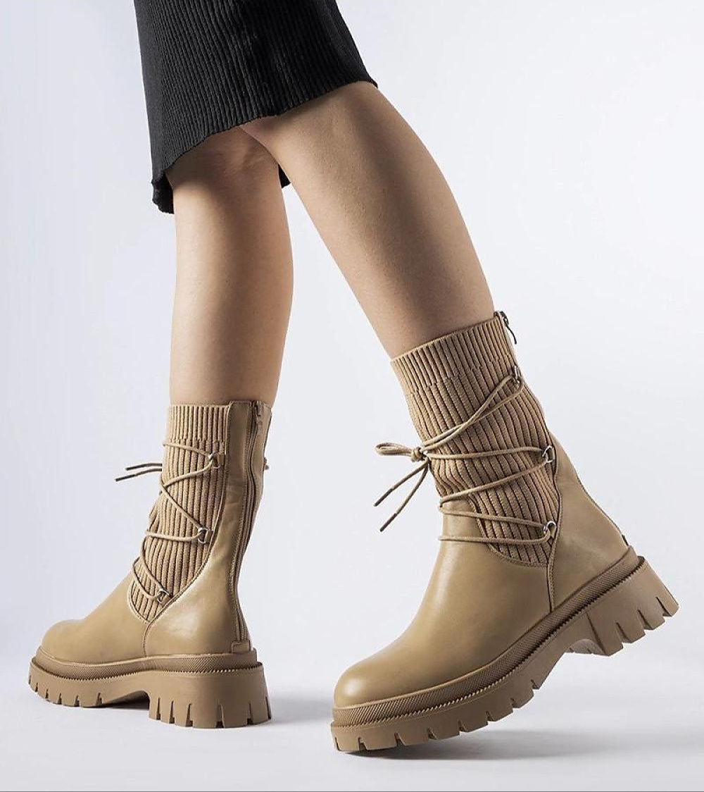 Beige sock boots with ribbed ankle design and lace-up detail, featuring chunky treaded soles. Perfect for winter style and comfort.