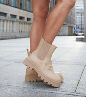 Side view of Bellantra High-Heel Zip Boots in deep beige, featuring a treaded sole, rounded toe, and full side zipper for easy wear.