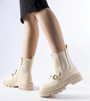 User wearing beige high-heel boots with a zip and treaded sole, showcasing stylish footwear suitable for casual or smart outfits.