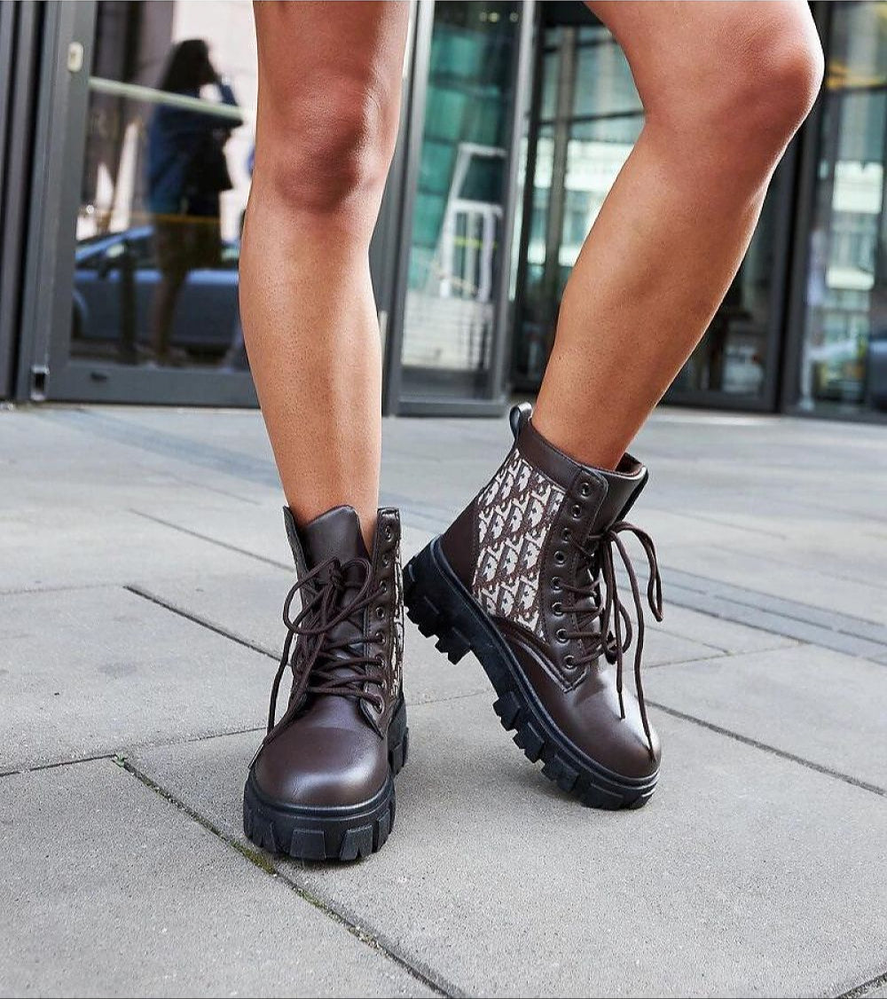 Woman wearing Ardenno Platform Lace-Up Boots in brown, showcasing their ankle-high design and platform sole on city sidewalk.