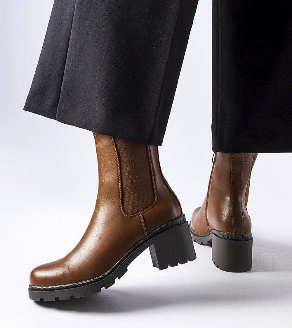 Brown Carserra ankle-heel boots in eco leather with stiletto heel, paired with black pants for elegant everyday wear.