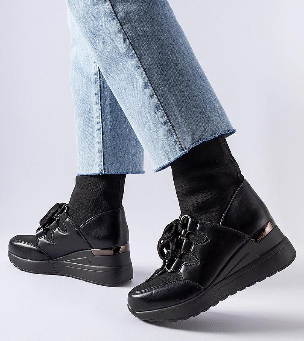 Person wearing Rochon Black Platform Buskin Boots with jeans, featuring a sleek design and 6 cm platform heel for style and comfort.